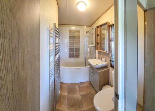 a bathroom with a tub and a sink and a toilet at Bainbridge Ings in Hawes