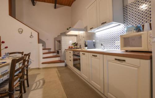 eine Küche mit weißen Schränken und einer Mikrowelle in der Unterkunft Stunning Home In Trappeto With Wifi in Trappeto