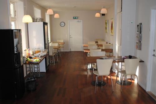 una sala con tavoli e sedie e una sala da pranzo di Det Lille Hotel a Rønne