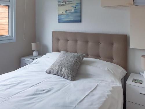 ein weißes Bett mit einem Kissen darüber in der Unterkunft Atlantic Retreat in Padstow