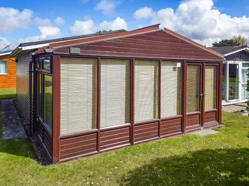 ein braunes und weißes Gebäude im Gras in der Unterkunft Atlantic Retreat in Padstow