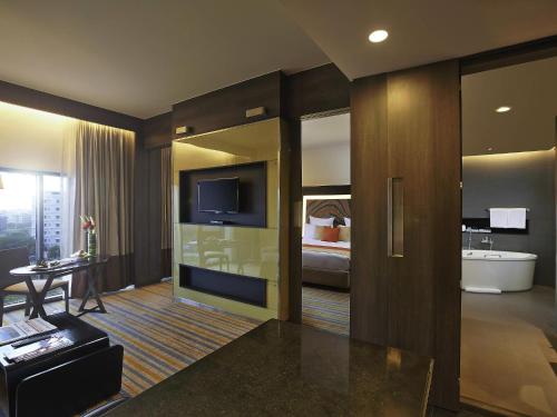 a hotel room with a tub and a suite at Novotel Kolkata Hotel and Residences in Kolkata