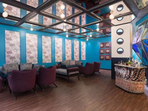 a dining room with blue walls and purple chairs at Novotel Kolkata Hotel and Residences in Kolkata