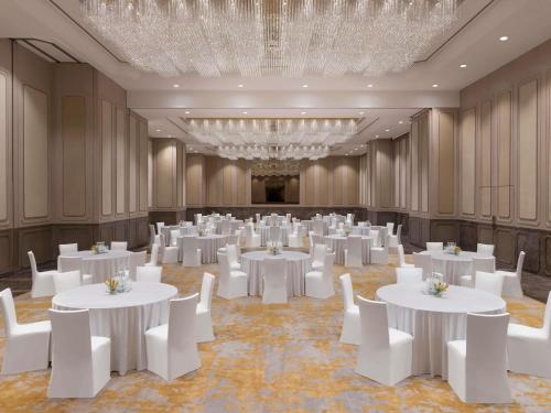 a banquet hall with white tables and white chairs at Novotel Kolkata Hotel and Residences in Kolkata