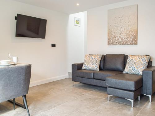 ein Wohnzimmer mit Sofa und Fernseher in der Unterkunft Hafan Gwyn - Cottage in Verwick