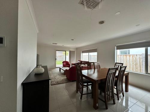 a dining room and living room with a table and chairs at Stylish four bedroom family retreat in Saltwater Coast in Point Cook