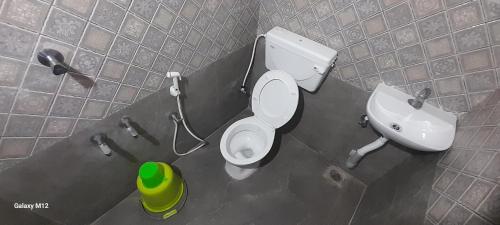 a bathroom with a toilet and a sink at Mahadev Residency in Tiruvannāmalai