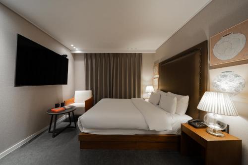 a hotel room with a bed and a television at Browndot Incheon Airport New City in Incheon
