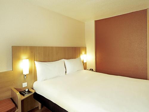 a large white bed in a hotel room at ibis Antofagasta in Antofagasta