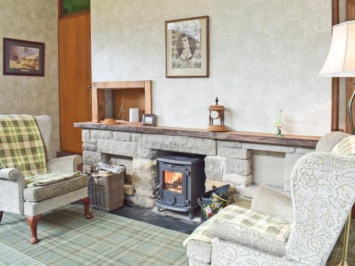 a living room with a stone fireplace and chairs at Glen Rosa in Ayr