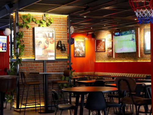 a restaurant with tables and chairs and a brick wall at ibis Antofagasta in Antofagasta