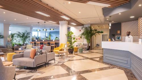 a lobby of a hospital with chairs and tables at Holiday Inn Algarve Albufeira by IHG in Albufeira