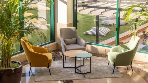 a group of chairs and a table in a lobby at Holiday Inn Algarve Albufeira by IHG in Albufeira