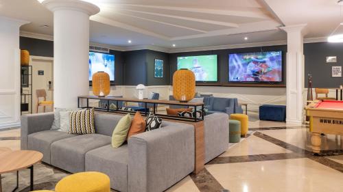 a living room with two couches and a flat screen tv at Holiday Inn Algarve Albufeira by IHG in Albufeira