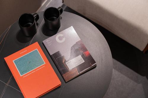 a table with two magazines and two cups on it at Browndot Incheon Airport New City in Incheon