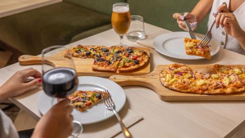 a group of people sitting at a table eating pizza at Holiday Inn Algarve Albufeira by IHG in Albufeira