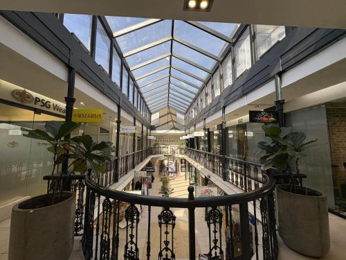 an indoor mall with a glass ceiling and plants at Hermanus Waterfront Boho Studio Apartment, Whale Coast Hideaway in Hermanus