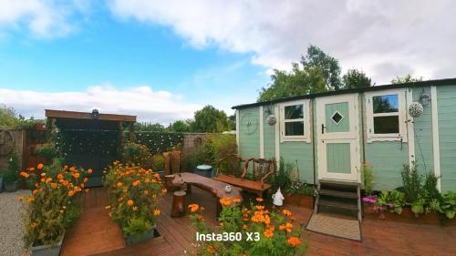 a tiny house in a garden with flowers at Alices Garden Two in York