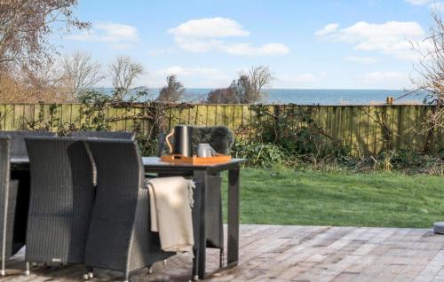 a table and chairs with a view of the ocean at Stunning Home In Endelave With Wifi in Sønderby