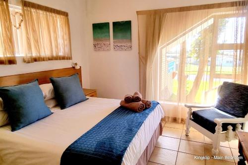 a bedroom with a bed with a teddy bear on it at Kleinmond Panorama Holidays in Kleinmond