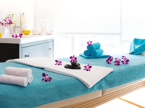 a bed with towels and flowers on top of it at Novotel Abu Dhabi Gate in Abu Dhabi