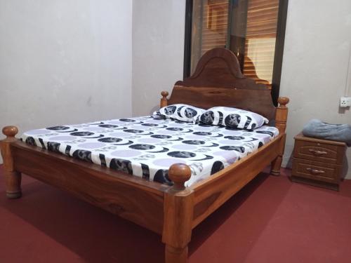 a bedroom with a wooden bed with a mirror at Balcony Bliss & Private Bath at Mamdalis in Ngambo