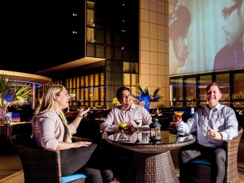 a group of people sitting at a table in a restaurant at Novotel Abu Dhabi Gate in Abu Dhabi
