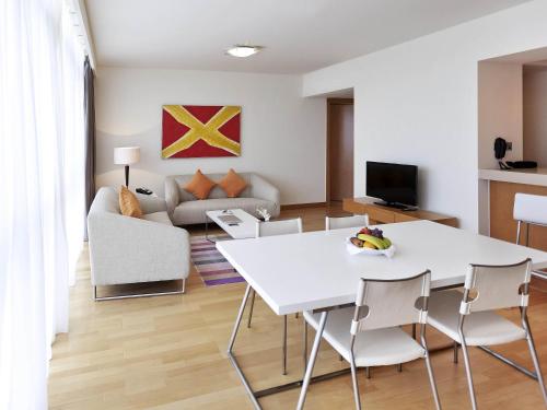 a living room with a white table and chairs at Ibis Abu Dhabi Gate in Abu Dhabi