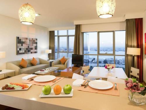 a living room with a table with fruits on it at Ibis Abu Dhabi Gate in Abu Dhabi