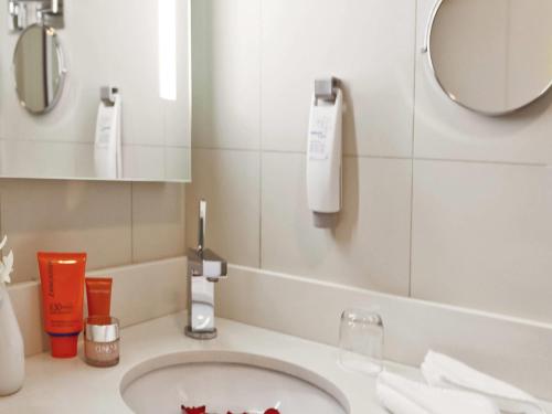 a bathroom with a sink and a mirror at Ibis Abu Dhabi Gate in Abu Dhabi