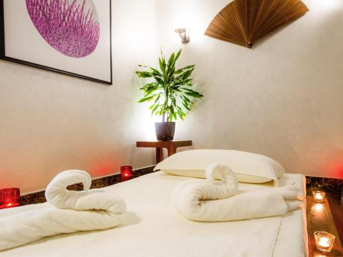 a room with two swans shaped towels on a bed at Ibis Abu Dhabi Gate in Abu Dhabi