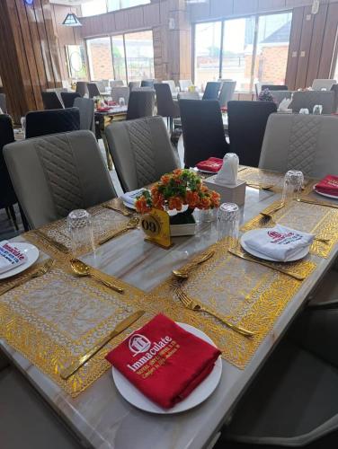 a table with plates and napkins on top at Immaculate Excellence Luxury Hotels Ltd in Owerri