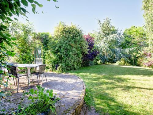 a table and chairs sitting in a garden at The Stables in Clyst Saint Mary