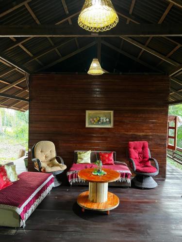 a living room with couches and a table and chairs at CasAmor Hostel in Alter do Chao