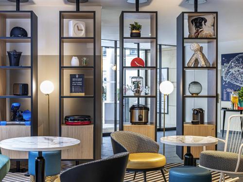 a room with tables and chairs and shelves at Aparthotel Adagio Paris Montrouge in Montrouge
