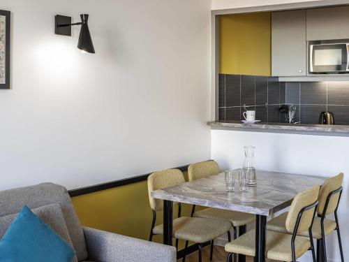 a dining room with a table and chairs at Aparthotel Adagio Paris Montrouge in Montrouge