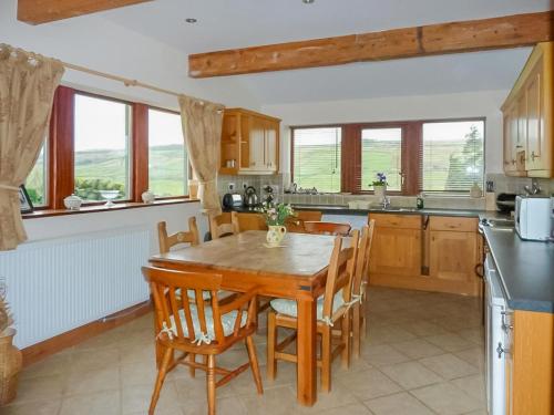 a kitchen with a wooden table and chairs at Royds Hall Cottage in Keighley