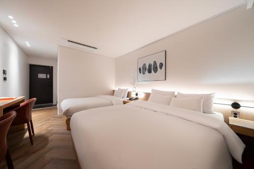 a hotel room with two beds and a table at Browndot Incheon Airport New City in Incheon