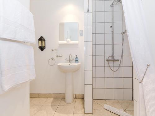 a white bathroom with a sink and a shower at Cherry Blossom in Thornton Dale
