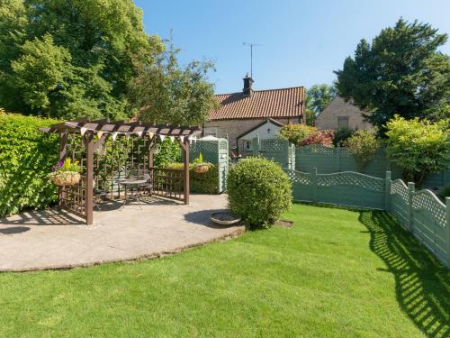 a garden with a gazebo and a fence at Cherry Blossom in Thornton Dale