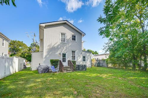 a white house with two chairs in the yard at Spacious Family Home with Yard in Dtwn Hampton! in Hampton