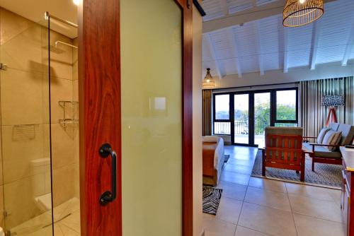 a bathroom with a walk in shower and a room at Hwange Safari Lodge in Dete