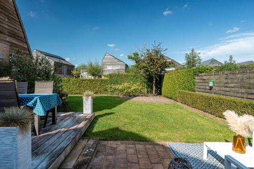 a backyard with a table and a lawn at Fries Vakantiehuis, grote tuin, nabij het Pikmeer in Grou