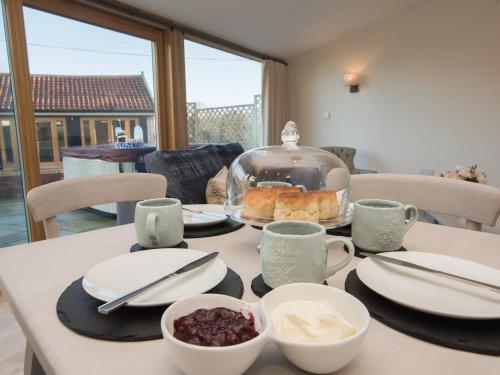 a table with a plate of food on it at Woodcrest Barn Cottage - Ukc1065 in Shelfanger