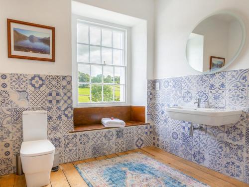 a bathroom with a sink and a toilet and a window at Fieldgate House in Bampton