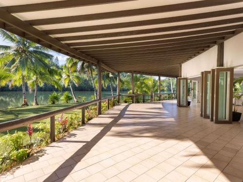 a pavilion with a view of the water and palm trees at Novotel Suva Lami Bay in Suva