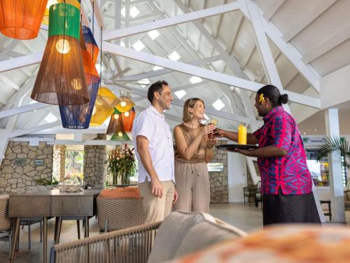 a group of three people standing in a restaurant at Novotel Suva Lami Bay in Suva