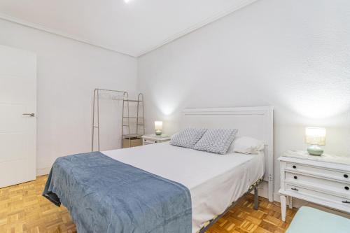 a white bedroom with a bed and a dresser at Your Large Family Apartment in Zaragoza in Zaragoza
