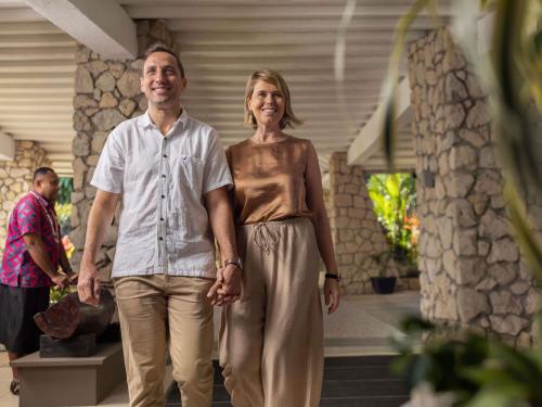 a man and a woman walking down the stairs of a house at Novotel Suva Lami Bay in Suva