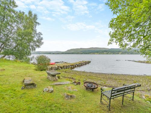 a park bench sitting next to a body of water at Uk47812 - Wardens Cottage in Kinloch Rannoch